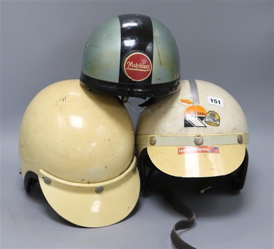 Three vintage racing helmets